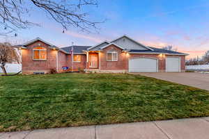 Ranch-style house featuring a yard and a garage