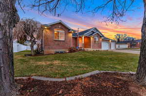 Ranch-style house featuring a yard and a garage