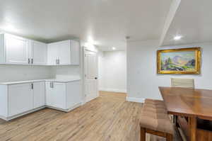 Kitchen featuring white cabinets and light hardwood / wood-style floors