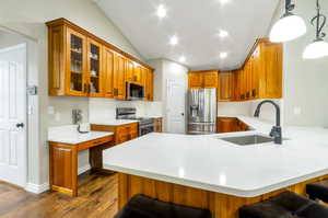 Kitchen featuring sink, appliances with stainless steel finishes, decorative light fixtures, a kitchen bar, and kitchen peninsula