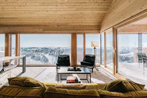 Sunroom with wood ceiling, lofted ceiling, and a mountain view