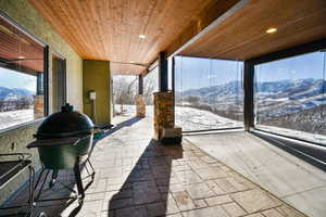 Patio with adjustable sun shades featuring a mountain view and wooden ceiling