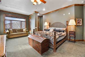 Carpeted bedroom featuring ceiling fan