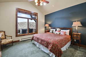 Carpeted bedroom featuring a mountain view, ceiling fan, lofted ceiling