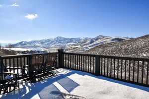 Snow covered deck with a mountain view