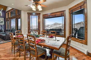 Dining space with a mountain view, light wood-type flooring, plenty of natural light, and ceiling fan