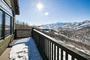 Snow covered back of property with a mountain view