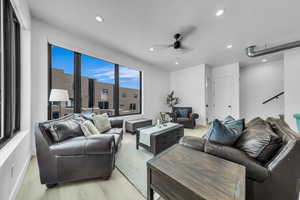 Living room with a textured ceiling, recessed lighting, baseboards, and ceiling fan
