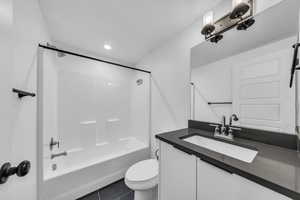 Full bathroom featuring tile patterned floors, toilet, vanity, and bathing tub / shower combination