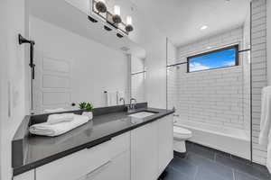 Bathroom with vanity, visible vents,  shower combination, tile patterned floors, and toilet