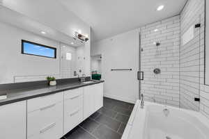 Bathroom with enclosed tub / shower combo, recessed lighting, tile patterned flooring, baseboards, and vanity