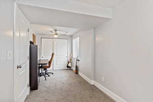 Office space featuring ceiling fan and light colored carpet