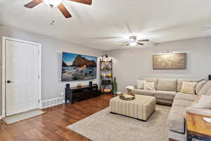 Living room featuring ceiling fan and dark hardwood / wood-style floors