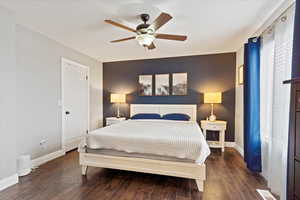 Bedroom with dark hardwood / wood-style floors and ceiling fan