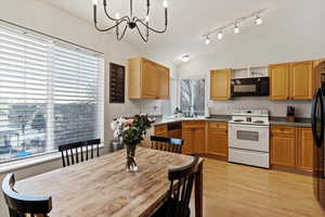 Kitchen featuring black appliances, lofted ceiling, a wealth of natural light, and light hardwood / wood-style flooring