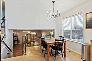 Dining area featuring ceiling fan with notable chandelier and light hardwood / wood-style floors