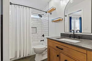 Full upstairs bathroom with shower / bath combo, vanity, toilet, and tile patterned floors