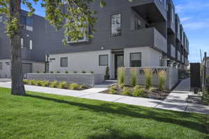 View of end unit front of home with a front yard