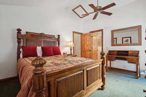 Carpeted bedroom with high vaulted ceiling and ceiling fan