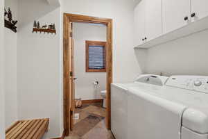 Washroom with cabinets and separate washer and dryer