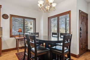 Dining space with light hardwood / wood-style flooring and a chandelier