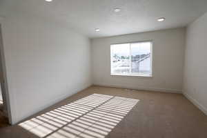 Unfurnished room featuring light carpet