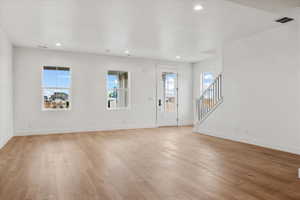 Foyer with light hardwood / wood-style floors and a textured ceiling