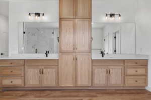 Bathroom featuring vanity, a shower with shower door, and hardwood / wood-style flooring