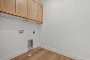 Laundry area featuring light hardwood / wood-style floors, washer hookup, cabinets, and hookup for an electric dryer