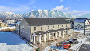 Snow covered house featuring a mountain view and central air condition unit