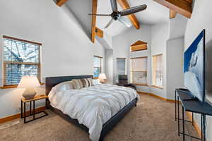 Master Bedroom with en suite bath, walk in closet, ceiling fan, large windows carpet , and high vaulted ceiling