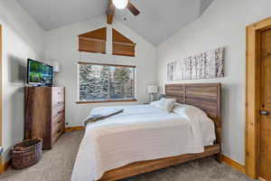 Carpeted bedroom with lofted ceiling with beams and ceiling fan