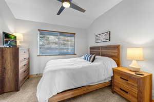 Carpeted bedroom featuring fan, walk in closet and high ceiling