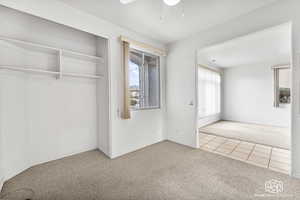 Unfurnished bedroom with carpet floors, a closet, and ceiling fan