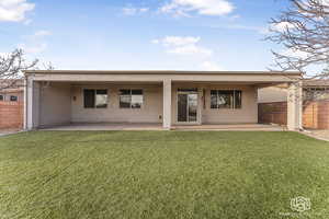 Rear view of house with a patio area and a yard