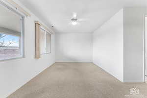 Carpeted spare room with ceiling fan