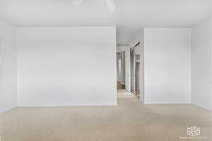 Empty room with light carpet and ceiling fan