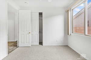 Unfurnished bedroom with light carpet and a closet