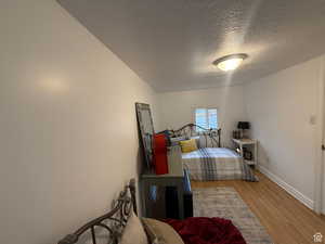 Bedroom with a textured ceiling and light wood-type flooring