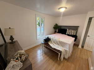 Bedroom featuring a textured ceiling and light hardwood / wood-style flooring