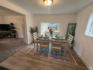 Dining space featuring hardwood / wood-style flooring and a textured ceiling