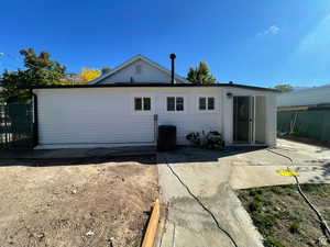 Rear view of house with a patio area and central AC