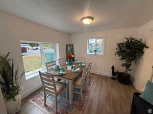 Dining area with hardwood / wood-style floors and a textured ceiling