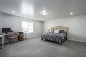 Bedroom featuring carpet flooring and a textured ceiling