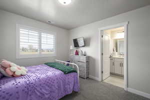 Bedroom with light carpet and ensuite bath