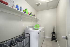 Washroom featuring separate washer and dryer and light tile patterned floors