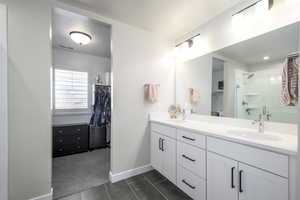 Bathroom with tile patterned flooring, vanity, and a shower with shower door