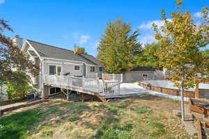 Rear view of property with a wooden deck and cooling unit