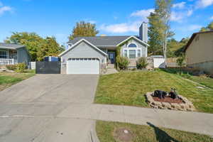 View of front facade featuring a garage and a front lawn