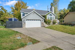 View of front facade featuring a garage and a front lawn